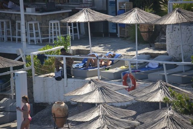 Sevgilisi denize girerken, Atakan deniz teklifini geri çevirip kitabına devam etti.