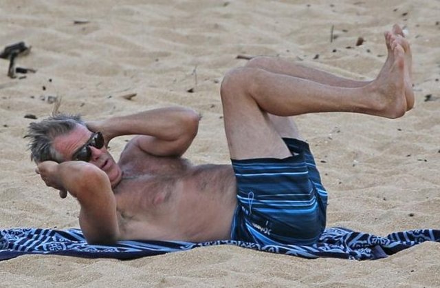 Plajda spor yapan, sere serpe güneşlenen eski 'James Bond' çevredekilere aldırış etmedi.