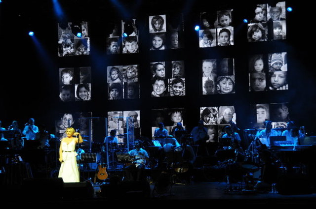 Sahne arkasına yapılan platformda Filistinli bombardıman mağduru çocukların fotoğraflarına yer veren Aksu konserine 'Tükeneceğiz' şarkısıyla başladı.