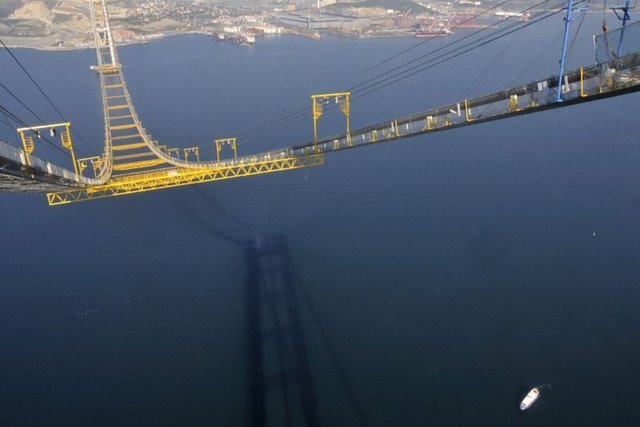 İstanbul ile İzmir arasındaki ulaşım süresini 9 saatten 3,5 saate indirecek Gebze-Orhangazi-İzmir Otoyolu Projesi'nin en büyük ayağını oluşturan İzmit Körfez Geçişi Asma Köprüsü'ndeki çalışmalar, Anadolu Ajansı (AA) ekibi tarafından kulelerin en yüksek noktasına çıkılarak görüntülendi.