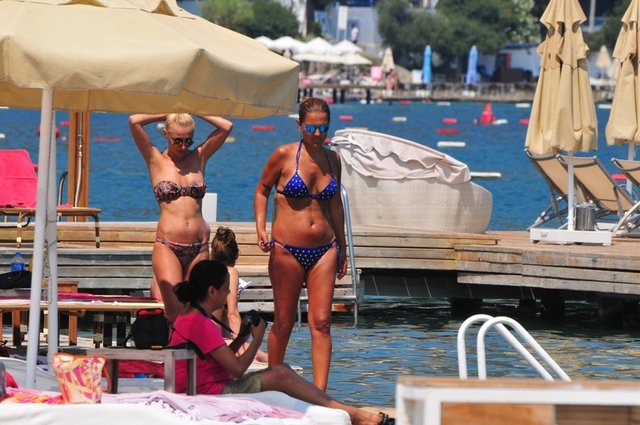 Bir kadın arkadaşıyla birlikte saatlerce güneşin ve denizin tadını çıkaran güzel şarkıcının yanında eşi Okan Kurt yoktu.