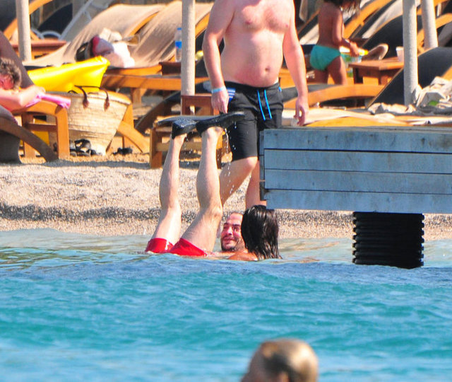 Esmer kız arkadaşıyla deniz keyfi yapan Kural ise suda yaptığı ilginç hareketlerle plajdakileri güldürdü.