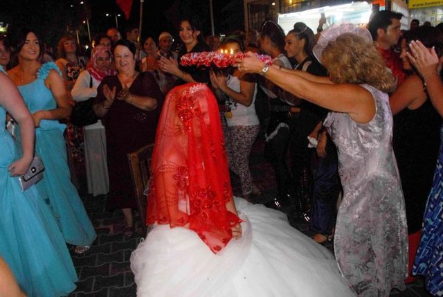 Türk ve İngiliz bayrakları eşliğinde davullar zurnalar çalınarak Hisarönü meydanına kadar gelin at, damat ve kayınpederi de deve üzerinde yol aldı. -