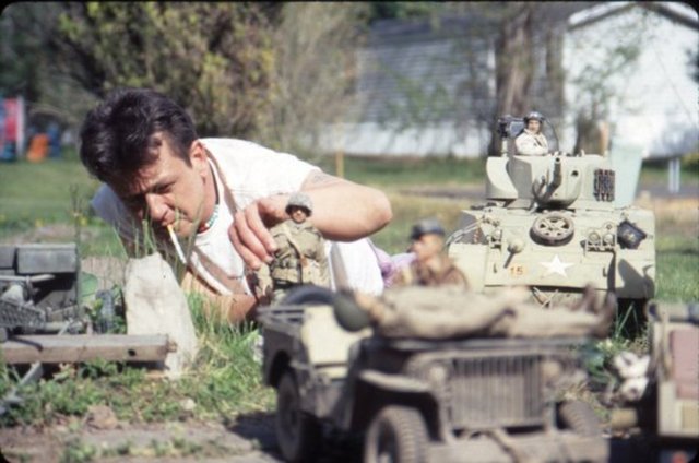 Mark terapisi süresince evinin bahçesini 2. Dünya Savaşı zamanındaki bir Belçika köyü gibi dizayn eden ve saldırganları da dahil hayatındaki herkesi oyuncaklarde temsil eden Mark,