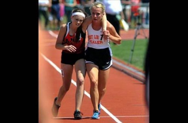 17 yaşındaki atlet Meghan Vogel, bitiş çizgisine varması için rakibine yardım ediyor.