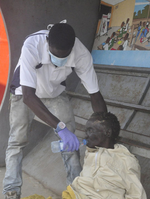 Liberya'da Ebola belirtileri gösteren bir hastaya, gönüllüler su veriyor.