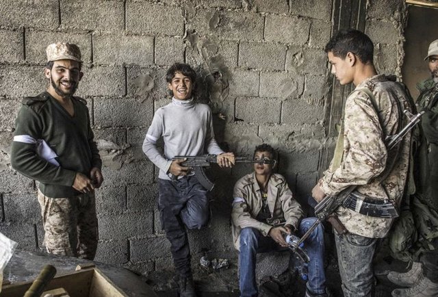 Libya'da, Trablus hükumetine bağlı Libya Şafağı Kuvvetleri ile Zintan güçleri arasında devam eden çatışmalarda Libya Şafağı güçleriyle birlikte hareket çocuklar, Sutre gerisinde bölgenin keskin nişancılardan temizlenmesini bekledi.  -  - 18.11.2014