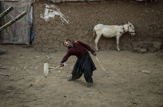 Aileleri Afganistan'daki savaş ortamından kaçarak Pakistan'a sığınan çocuklar, hayatlarını sürdürmek için İslamabad'daki mülteci mahellesinde zor şartlar altında yaşıyor. Çocuklar eğlenmek için şişe ve sopalarla oyun oynuyor.  -  - 20.11.2014