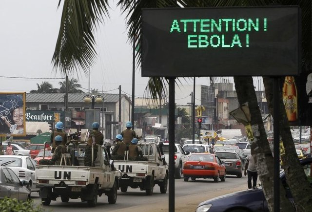 Abidjan'da bir BM asker konvoyu, caddede Ebola ile ilgili mesaj yazan ekranın önünden geçiyor. (Ivory Coast, 14 Ağustos 2014, REUTERS/Luc Gnago)