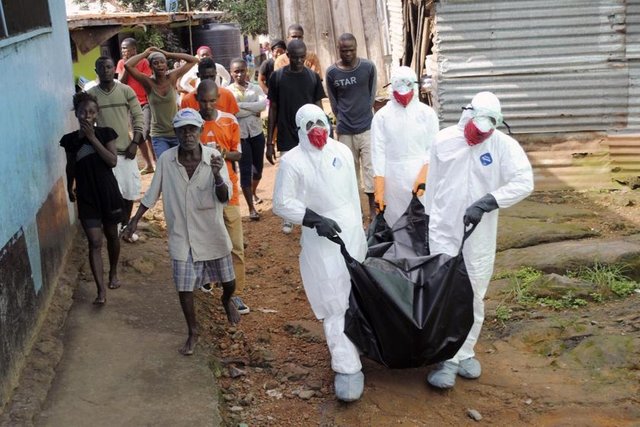 Sağlık çalışanları Monrovia'da, Ebola'dan öldüğü söylenen 29 yaşındaki Prince Nyentee'nin bedenini kaldırıyor. (11 Eylül 2014, REUTERS/James Giahyue)