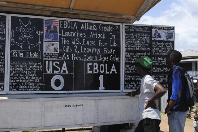 Yerli halk, Daily Talk'un (yol kenarındaki kara tahta gazetesi) Ebola:1 Amerika:0 manşetini okuyor.  (Monrovia - Liberya, 16 Ekim 2014, REUTERS/James Giahyue)
