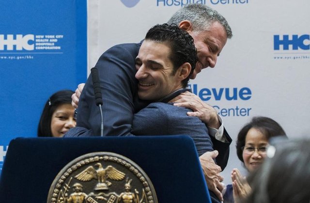 New York Belediye Başkanı Bill de Blasio, Ebola'ya yakalanıp Bellevue Hastanesi'nde 3 hafta izolasyon tedavisi gördükten sonra taburcu olan Dr. Craig Spencer'a sarılıyor. (11 Kasım 2014, REUTERS/Lucas Jackson)