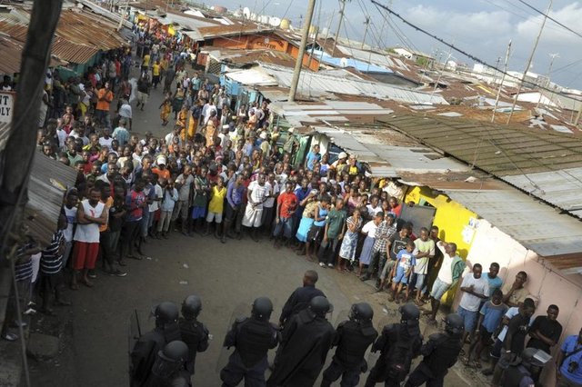 Liberya güvenlik güçleri, Monrovia'daki West Point Mahallesi'nde yaşanan çatışmalar sonrası protestocuların önünde duruyor. (Liberya, 20 Ağustos 2014, REUTERS/2Tango)