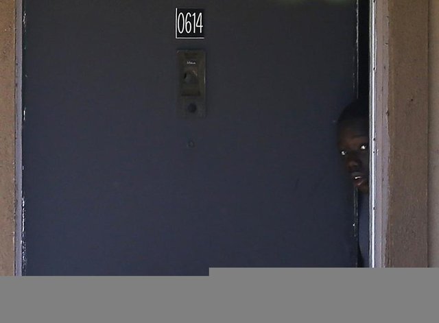 Bir kişi, Dallas'ta Ebola teşhisi konulan birinin yaşadığı apartman dairesinden gizlice dışarı bakıyor. (Teksas, 3 Ekim 2014, REUTERS/Jim Young)