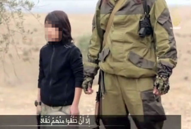 Burada artık "Halife'nin yavru aslanlarının" gözetiminde oldukları söylenen iki adam, bir çocuk tarafından infaz ediliyor.