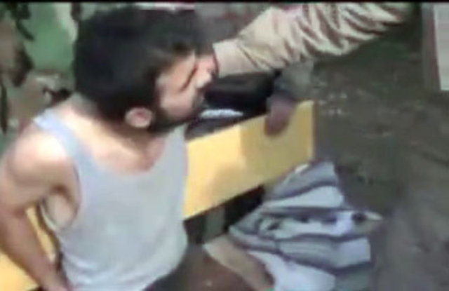 Askerin yalvarmasına aldırmadan vahşice boğazını kesen teröristler, askerin kafasını kestikten sonra bedeninin üstüne koyuyor.