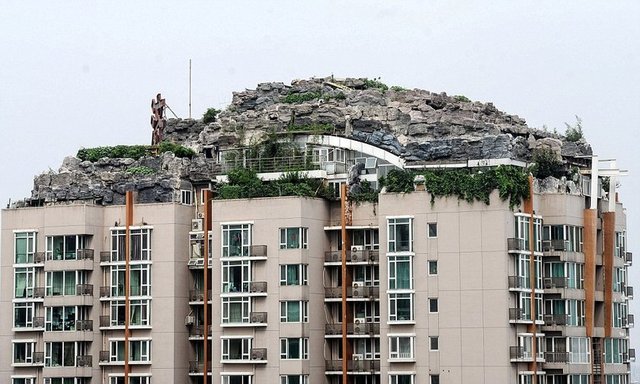 Çin'de 26 katlı bir apartmanın çatı katına dağ görünümlü villa yapan adam görenleri hayrete düşürdü.