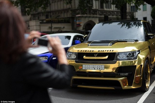 Bir hayranı altın kaplamalı Range Rover Hamann Mystere'i fotoğraflıyor.  -