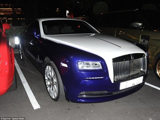 Bu Rolls Royce gece açık bir otoparkta duruyor.  -