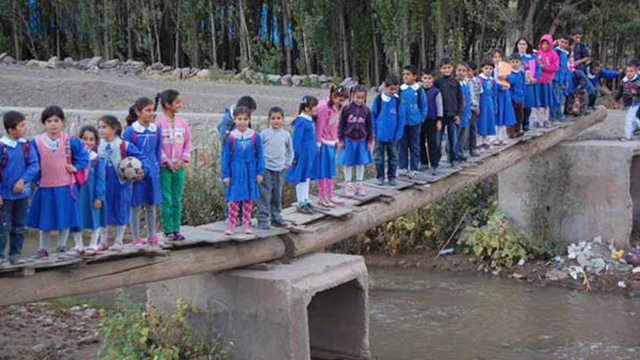 TÜRKİYE / MUŞ - MUŞ'un Korkut İlçesi'ne bağlı Altınova Beldesi'nde Çaksor Deresi üzerine ağaç direk ve tahta kullanılarak yapılan köprüden geçip okula giden öğrenciler, korku dolu anlar yaşıyor.