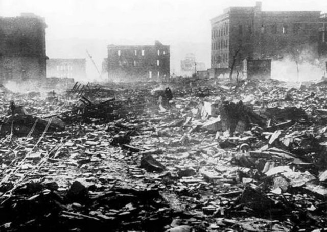 Nagasaki'nin yanıp küle dönmüş yıkıntılarının arasında yürüyen insanlar. Patlamanın 3900 derece sıcaklığa ulaştığı tahmin ediliyor.