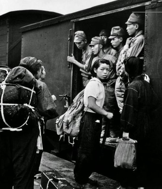 Siviller ve terhis olan askerler trenlerle Tokyo'ya gitmeye çalışıyor, trenler kalabalık, yer bulmak çok zor.