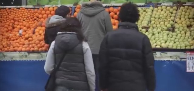 Manavda bir vatandaş elindeki poşette bulunan meyveleri düşürüyor.