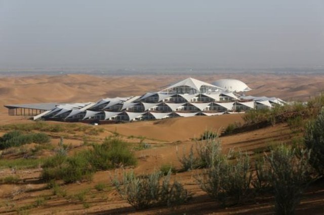 "Desert Lotus Hotel", yapı olarak üçgen beyaz çadır ile üstleri kapatılmış bir tasarıma sahip ve bir lotus gibi 45 derece döndürülmüş dairesel oluşum ile birbirine bağlı.