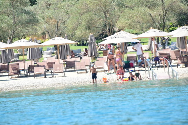 Bir beach'te çocuklarıyla oyunlar oynayan Şıkel, fit vücuduyla ilgi odağı oldu.
