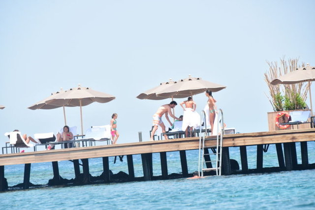 Denizden çıkan ikili, havlulara sarılıp muhabirlerin gitmesini bekledi.