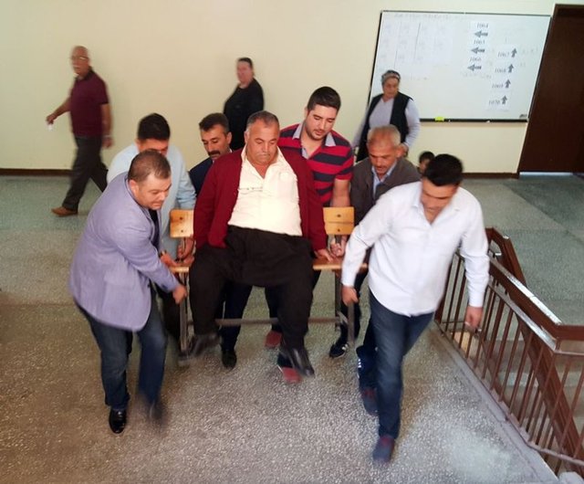 Osmaniye'nin Kadirli ilçesinde bedensel engelli vatandaş, okul sırası üzerine oturtulup 6 kişinin yardımıyla 3. kattaki oy sandığına taşındı.