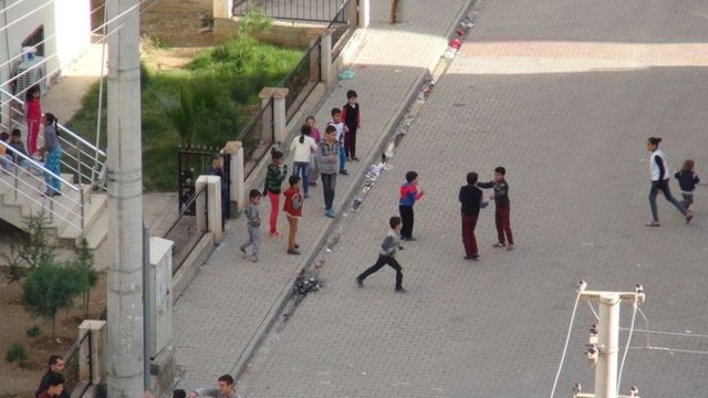 Gıda sıkıntısının da baş göstermeye başladığı ilçede bir haftadır yasak nedeniyle dışarı çıkamayan çocuklar, patlama ve silah sesleri altında çıktıkları sokaklarda oyun oynamaya çalışırken, bazı vatandaşların ise evlerinin damına çıktığı görüldü.DHA 