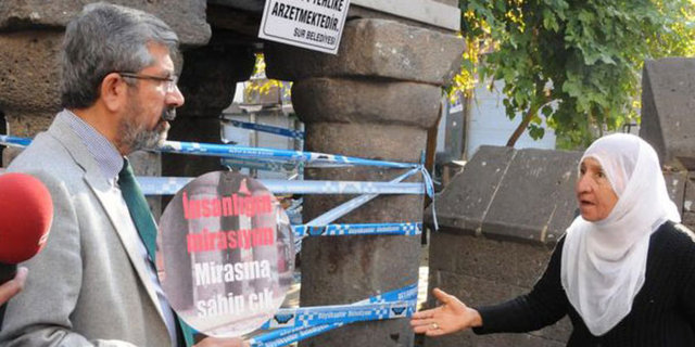 Elçi yaşlı bir kadınla ayaküstü sohbet etmeye başladı.