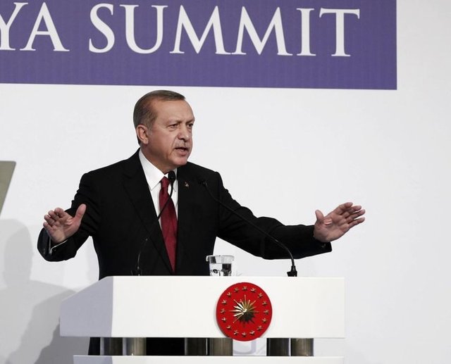 Gerginliği kontrol etmeyi amaçlayan soğukkanlı bir yaklaşım. Aynı zamanda kendi gücünü de ortaya koyacak şekilde kollarını açmış.