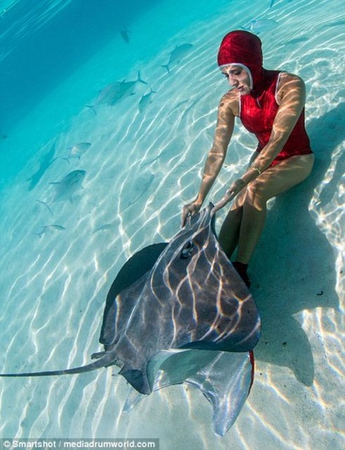 Vatozlarla bol bol fotoğraf çekilen bikinili kızlar balıkları beslerken böyle görüntülendi.