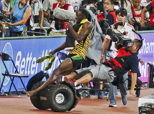 Reuters, 2015 yılının en iyi spor fotoğraflarını seçti2) Pekin'de düzenlenen Dünya Atletizm Şampiyonası'ndayız. 200 metre finalini kazanan Usain Bolt sevincini yaşarken hızını alamayan bir kameraman tarafından yanlışlıkla düşürülüyor.