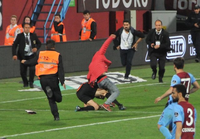 Örgülerin sökülmesi üzerine sahaya yabancı maddeler atan taraftarlardan birkaçı güvenlik görevlilerine rağmen sahaya girdi. -  