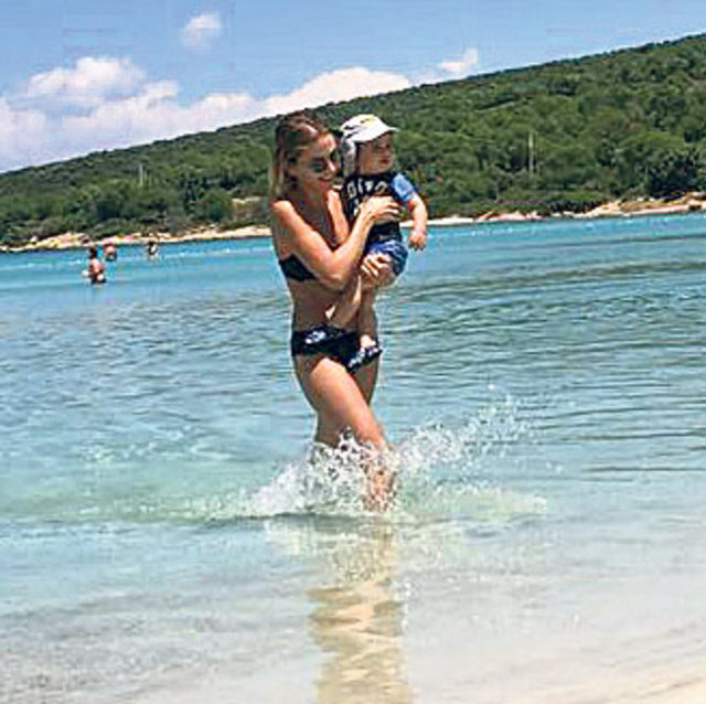 Bir beachte oğluyla denize giren Erken, düzgün fiziğiyle dikkat çekti. (Posta)