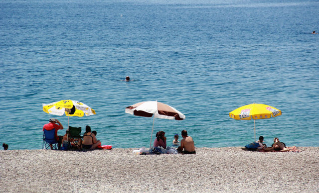 Hava sıcaklığının 40 derece, deniz suyu sıcaklığının 24 derece olarak ölçüldüğü Antalya'da yerli ve yabancı turistler sahillerde serinlemeye çalıştı.