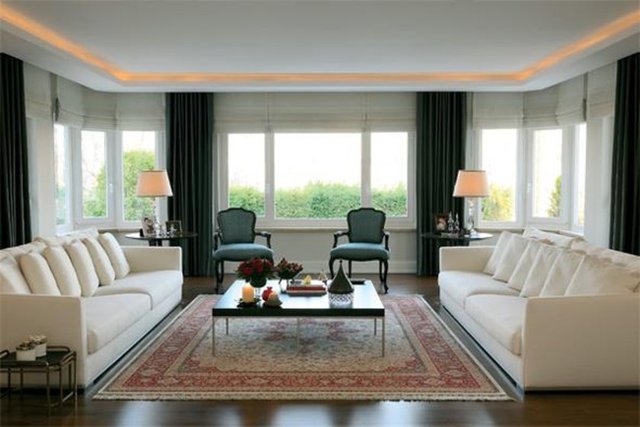 Yeşillikler içindeki villanın giriş katında bir kısmı yemek bölümü olarak tasarlanan devasa salon var.