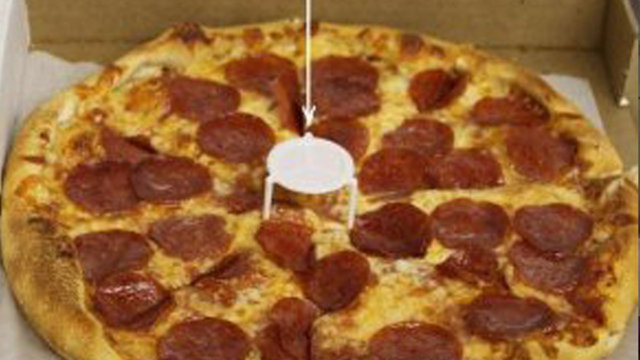 PİZZA KUTUSUNDAN ÇIKAN PLASTİK Pizza kutusunun tam ortasında bulunan beyaz plastik nesnenin amacı sıcak pizzanın kutu ile temasını önlemek.