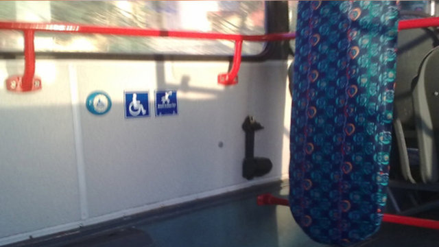 TOPLU TAŞIMA OTOBÜSLERİNDEKİ ÜTÜ MASASINA BENZEYEN ŞEYAmacı, tekerlekli sandalyedeki engelli vatandaşların sorunsuz bir şekilde yolculuk etmesini sağlamaktır. Bu alanda, tekerlekli sandalye, emniyet kemeri ile bağlanarak güvenli yolculuk yapılır.