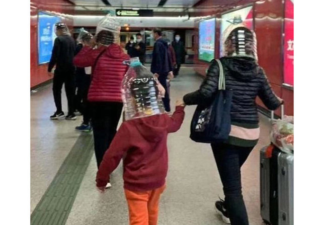 Hong Kong metro istasyonunda da bir anne çocuğunun ve kendi kafasına yarısına kadar kesilmiş bir şişe geçirerek çocuğunu ve kendini virüsten korumaya çalıştı. 