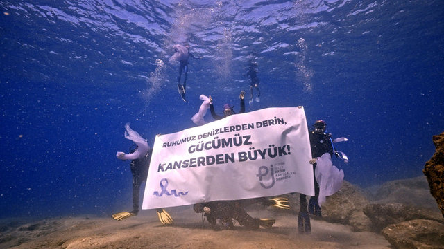 EKİP DAHA SONRA SU ALTINDA PANKART AÇARAK 'GÜCÜMÜZ KANSERDEN BÜYÜK' MESAJI VERDİLER.