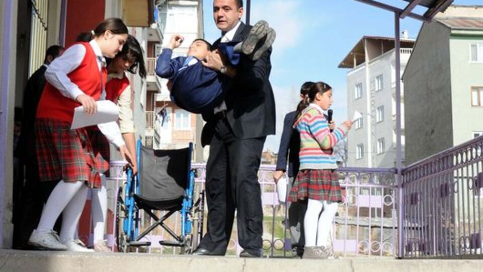 Engelli öğrencisini 4 yıldır kucağında taşıyor