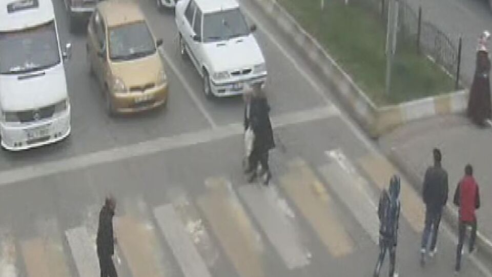 Aracından inip yaşlı adamı karşıya geçirdi