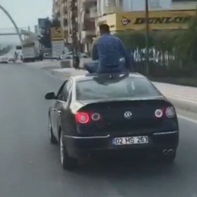 Otomobilin üstüne oturarak yolculuk yaptı