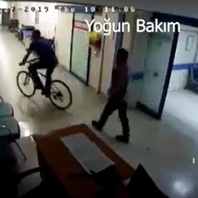 Hastane koridorunda bisiklet süren doktor kamerada