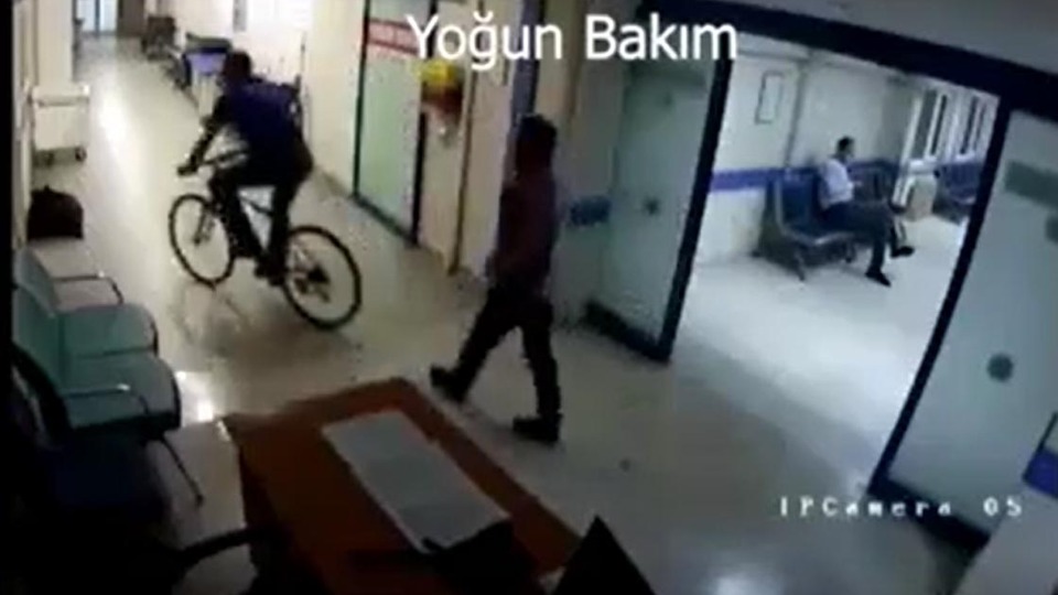Hastane koridorunda bisiklet süren doktor kamerada
