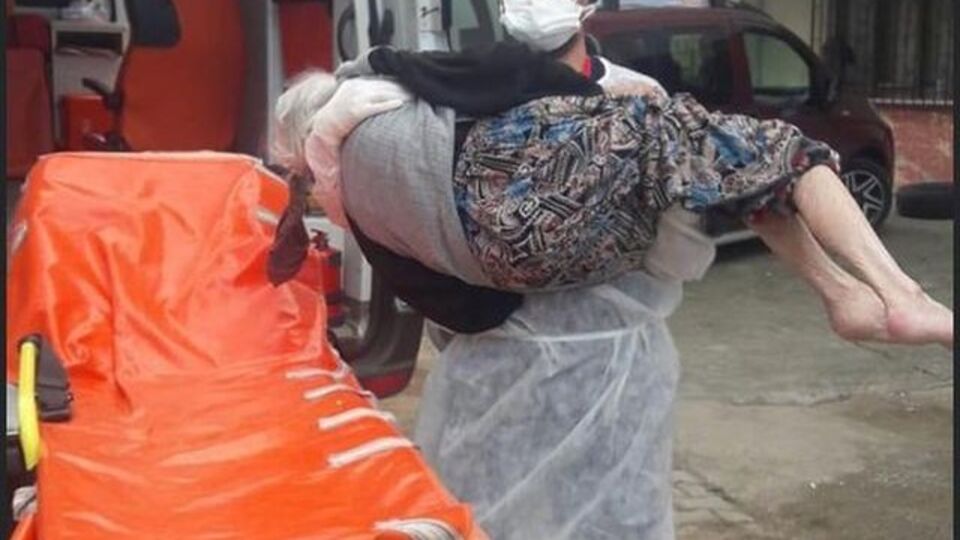 Karantinaya alınacak yaşlı kadını kucağında taşıdı